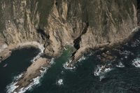 Coastal View: Ocean Cliffs and Contrails