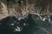 Coastal View: Ocean Cliffs and Contrails