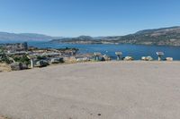 an empty parking lot overlooks the city and the lake as seen from the top of a hill