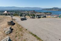 an empty parking lot overlooks the city and the lake as seen from the top of a hill