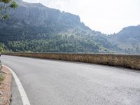 a motorcycle is riding down the road near the mountains in frances dordoc