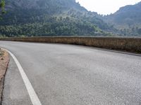 a motorcycle is riding down the road near the mountains in frances dordoc