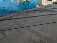 a body of water that has a concrete surface on the ground and some buildings in the background