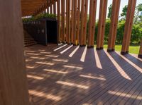 a walkway between the rooms is made from wood and has been designed in a way that allows sunlight to reach