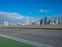 a freeway highway with city skyline in the background on a sunny day, near the beach