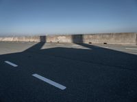 the shadow of an airplane is cast on the road by the ocean as it passes over the bridge