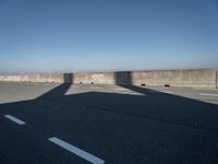 the shadow of an airplane is cast on the road by the ocean as it passes over the bridge