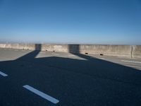 the shadow of an airplane is cast on the road by the ocean as it passes over the bridge