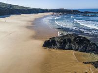 there is a rocky beach next to the ocean in the sun, as well as the water