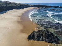 there is a rocky beach next to the ocean in the sun, as well as the water