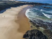 there is a rocky beach next to the ocean in the sun, as well as the water