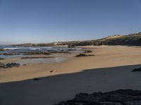 a beach area with a rocky shoreline and an ocean shoreline in the background and a beach on top of it