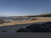 a beach area with a rocky shoreline and an ocean shoreline in the background and a beach on top of it