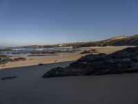 a beach area with a rocky shoreline and an ocean shoreline in the background and a beach on top of it