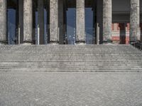 there is a man with an umbrella walking up some steps in front of a large building