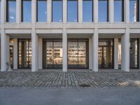 the large office building is located in the center of a cobblestone plaza of the city