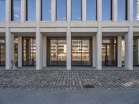 the large office building is located in the center of a cobblestone plaza of the city
