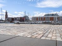 a cobblestone road in an outdoor setting with boats docked at the water's edge