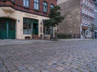 this street is a cobble stone road in europe which has the name of a small store