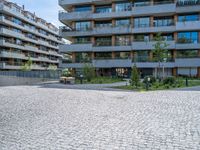 an empty cobblestone road near a parking garage and office buildings in a modern urban area