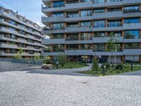 an empty cobblestone road near a parking garage and office buildings in a modern urban area