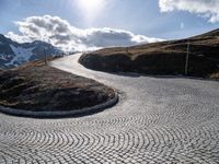 a paved road winds its way to the top of the mountain in switzerland or austria