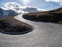 a paved road winds its way to the top of the mountain in switzerland or austria