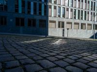 a black motorcycle is parked on a cobble - stone street in front of buildings