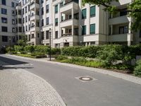 a stone sidewalk in front of an apartment building in germany, as well as landscaping