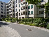 a stone sidewalk in front of an apartment building in germany, as well as landscaping