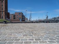 a brick walkway that leads to a boat dock in a harbor with buildings next to it