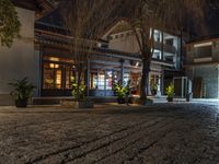 an empty cobblestone street in a historic city at night with people and shops