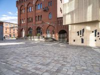 the brick street has a few steps leading up to several building with windows on them