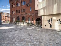 the brick street has a few steps leading up to several building with windows on them