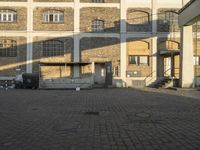 an old building with lots of windows and doors that are open on the front yard