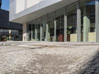 a view of a building near the street that has large windows with reflective glass on them