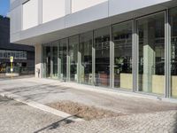 a view of a building near the street that has large windows with reflective glass on them