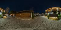 two fisheye photos in one showing a cobbled street and some houses at night