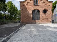 brick walkway that connects to the brick building with the arched window that surrounds it,