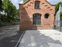 brick walkway that connects to the brick building with the arched window that surrounds it,