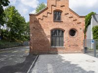 brick walkway that connects to the brick building with the arched window that surrounds it,