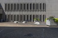 there are stone plants pots with flowers in them on the patio of a building's exterior