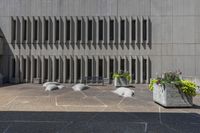 there are stone plants pots with flowers in them on the patio of a building's exterior