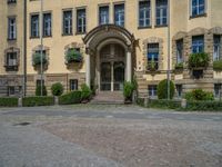 large yellow building with some plants and bushes in front of it for decoration or entertainment