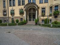 large yellow building with some plants and bushes in front of it for decoration or entertainment