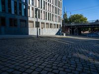 a cobblestone path passes through an old building in the sun, with one end showing