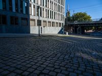 a cobblestone path passes through an old building in the sun, with one end showing