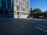 a cobblestone path passes through an old building in the sun, with one end showing