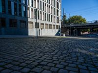 a cobblestone path passes through an old building in the sun, with one end showing