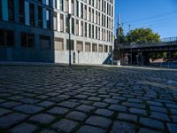 a cobblestone path passes through an old building in the sun, with one end showing